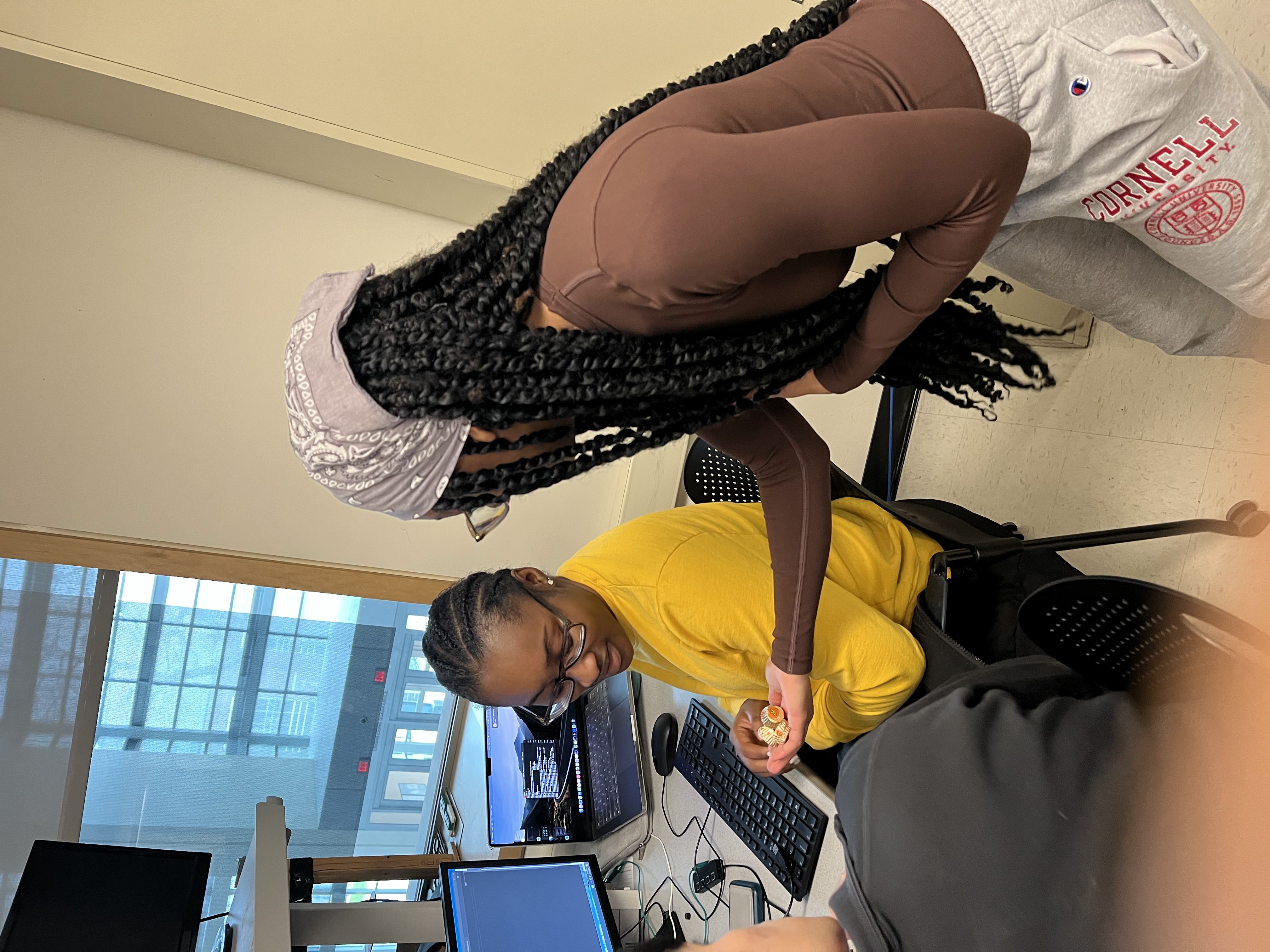 This image slider contains images of NSBE-CU's Sweet Tools for Success Event. The first image of this slider depicts one NSBE member handing another member a handful of sweets.